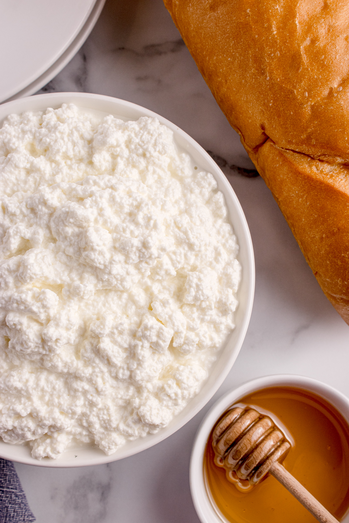 Fresh ricotta in a bowl served with bread and honey