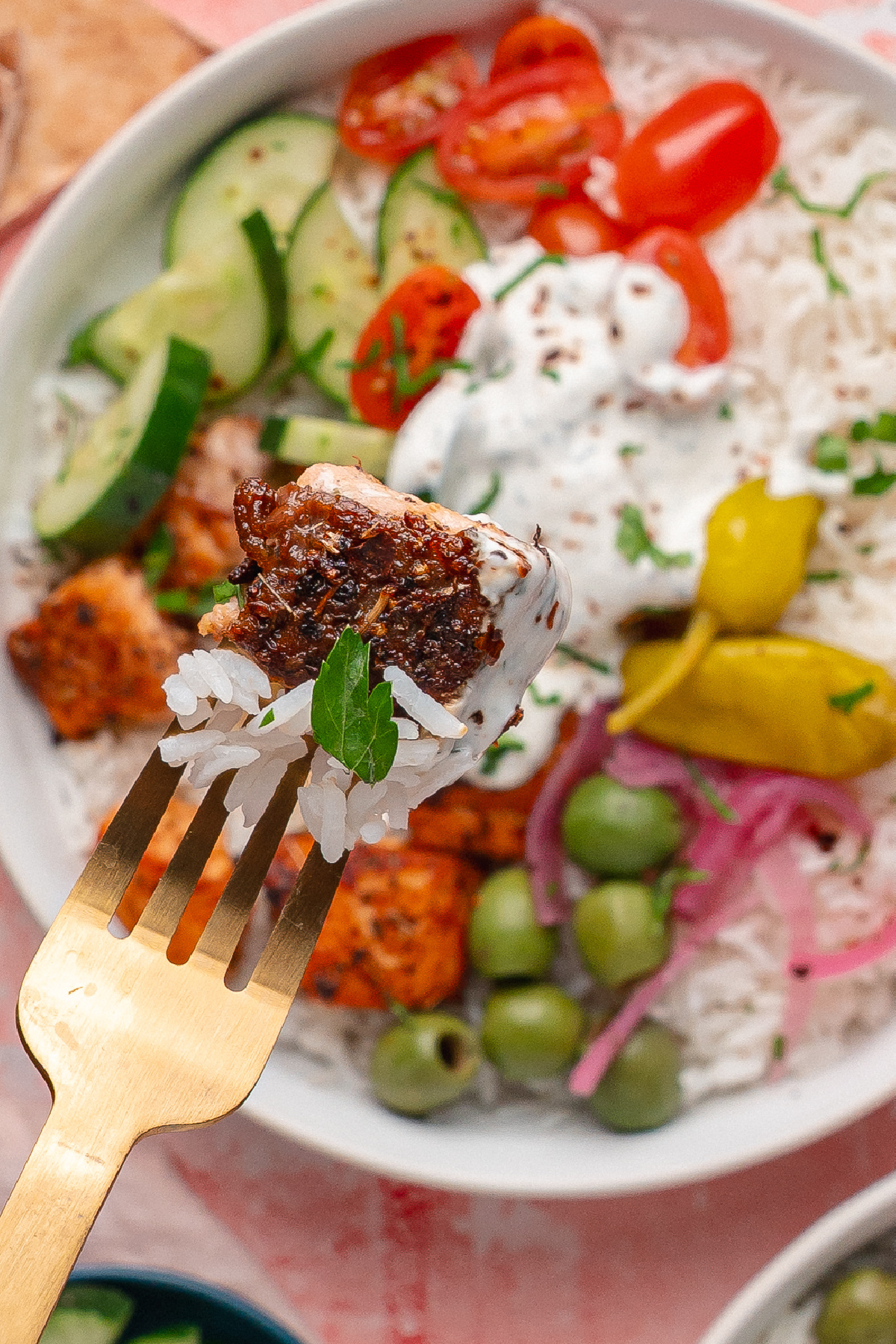 Greek Salmon Rice Bowl with crispy salmon bites, white rice, yogurt dill sauce, olives, cucumber, and pickled red onions