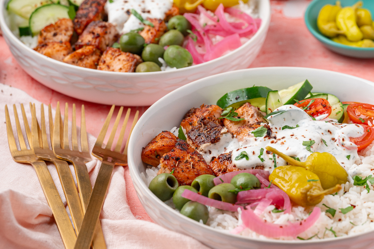 Greek Salmon Rice Bowl with seared salmon bites, white rice, yogurt dill sauce, olives, and pickled red onions