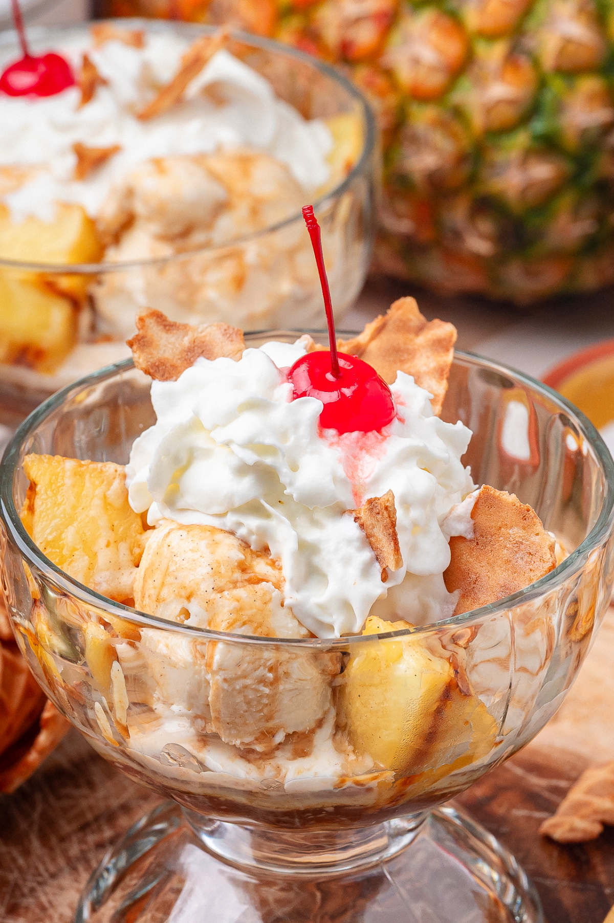 Spoonful of grilled pineapple sundae with hot buttered rum sauce and melting vanilla ice cream