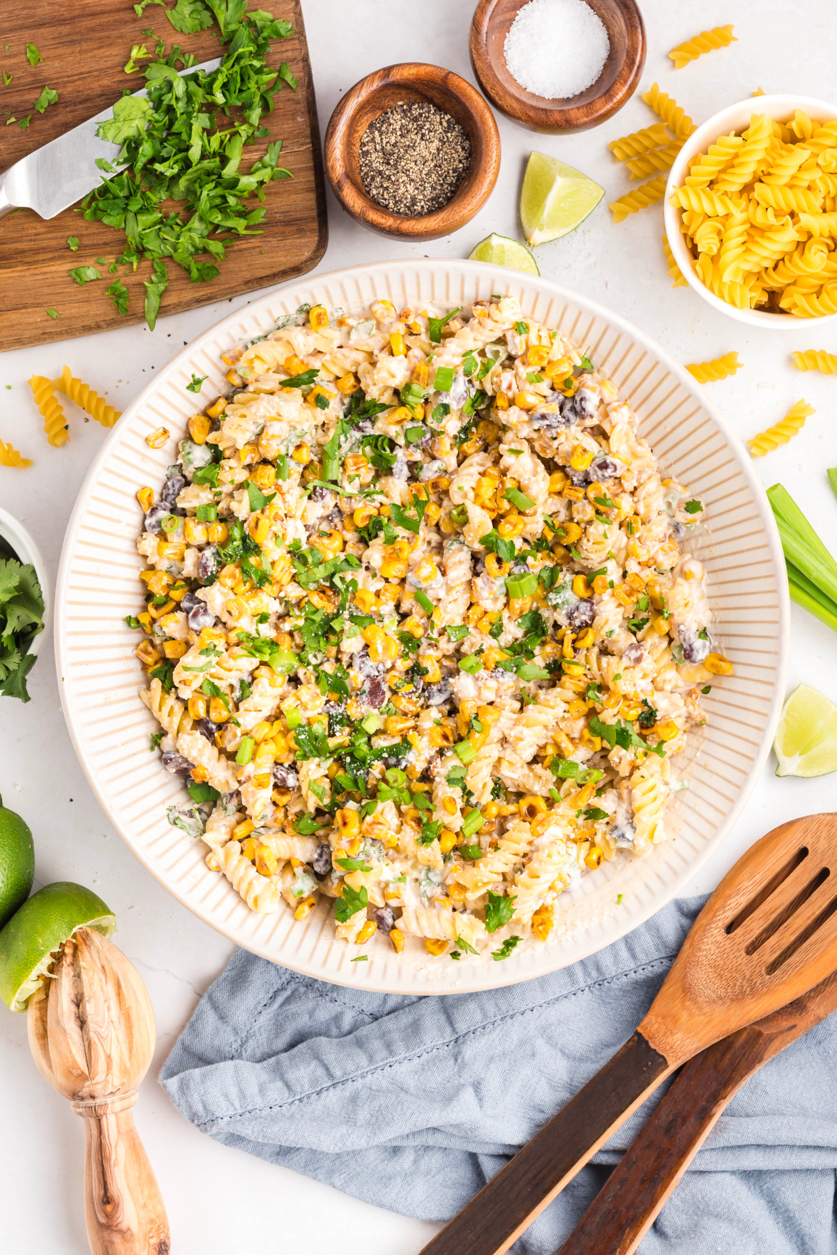 Mexican street corn pasta salad served in a large bowl with chopped cilantro, green onions, and golden corn