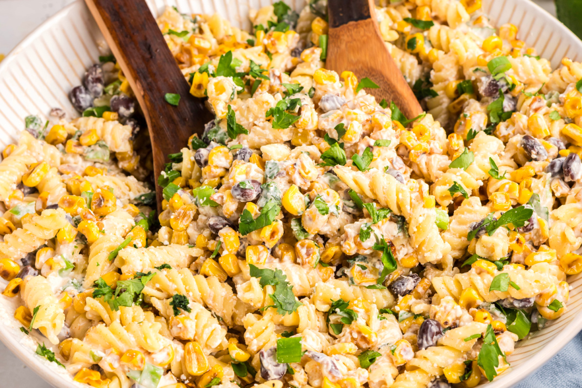 Creamy street corn pasta salad with rotini, golden corn, black beans, cotija, and fresh cilantro in a large serving bowl
