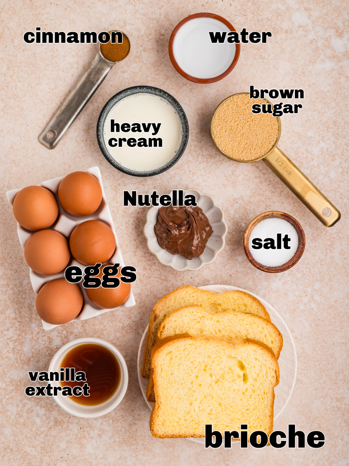 Ingredients for chocolate hazelnut French toast casserole including brioche bread, eggs, heavy cream, brown sugar, cinnamon, vanilla, and Nutella