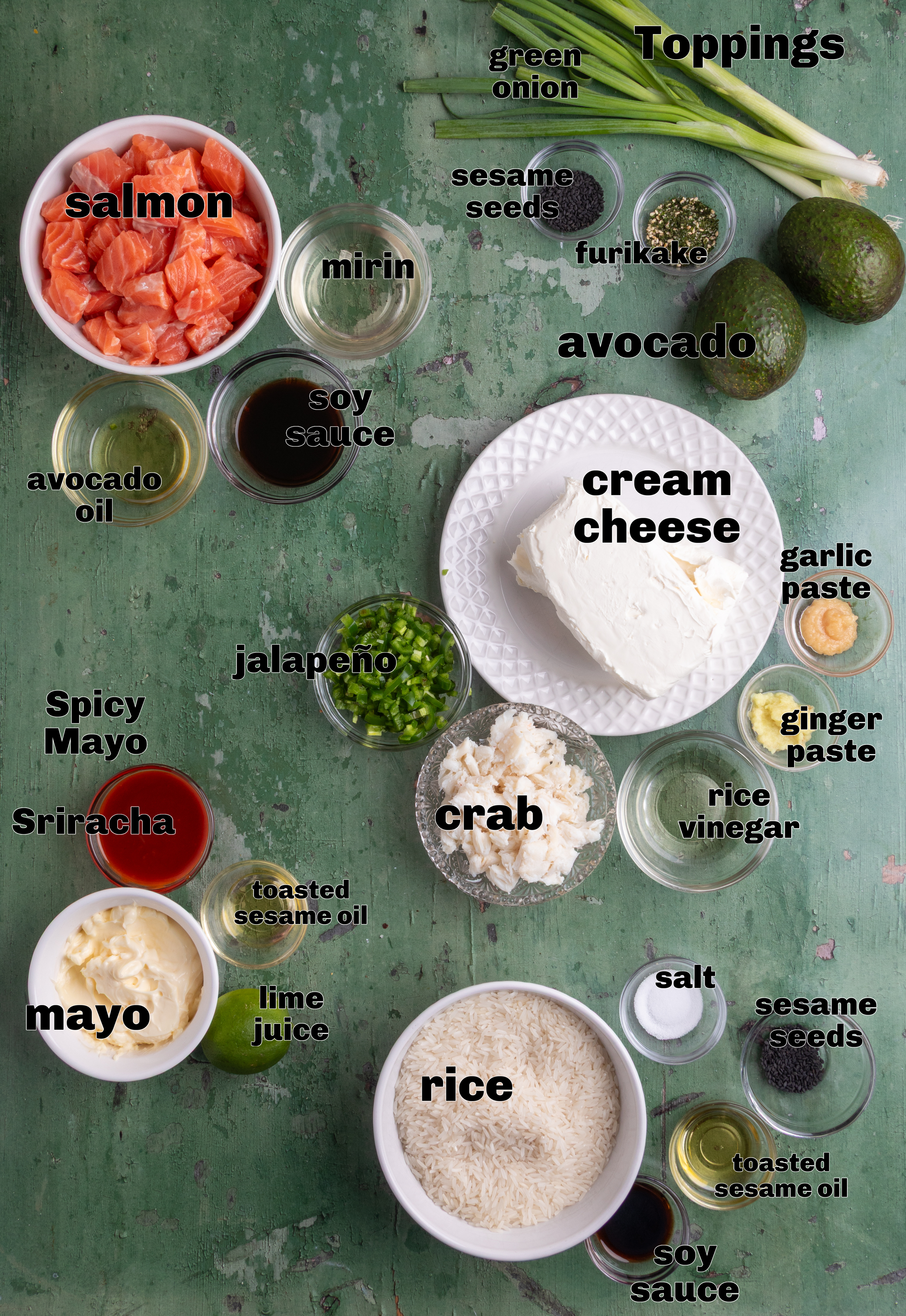 Ingredients for sushi bake including salmon, lump crab, jasmine rice, cream cheese, jalape&ntilde;o, soy sauce, mirin, mayonnaise, Sriracha, avocado, sesame seeds, and green onions
