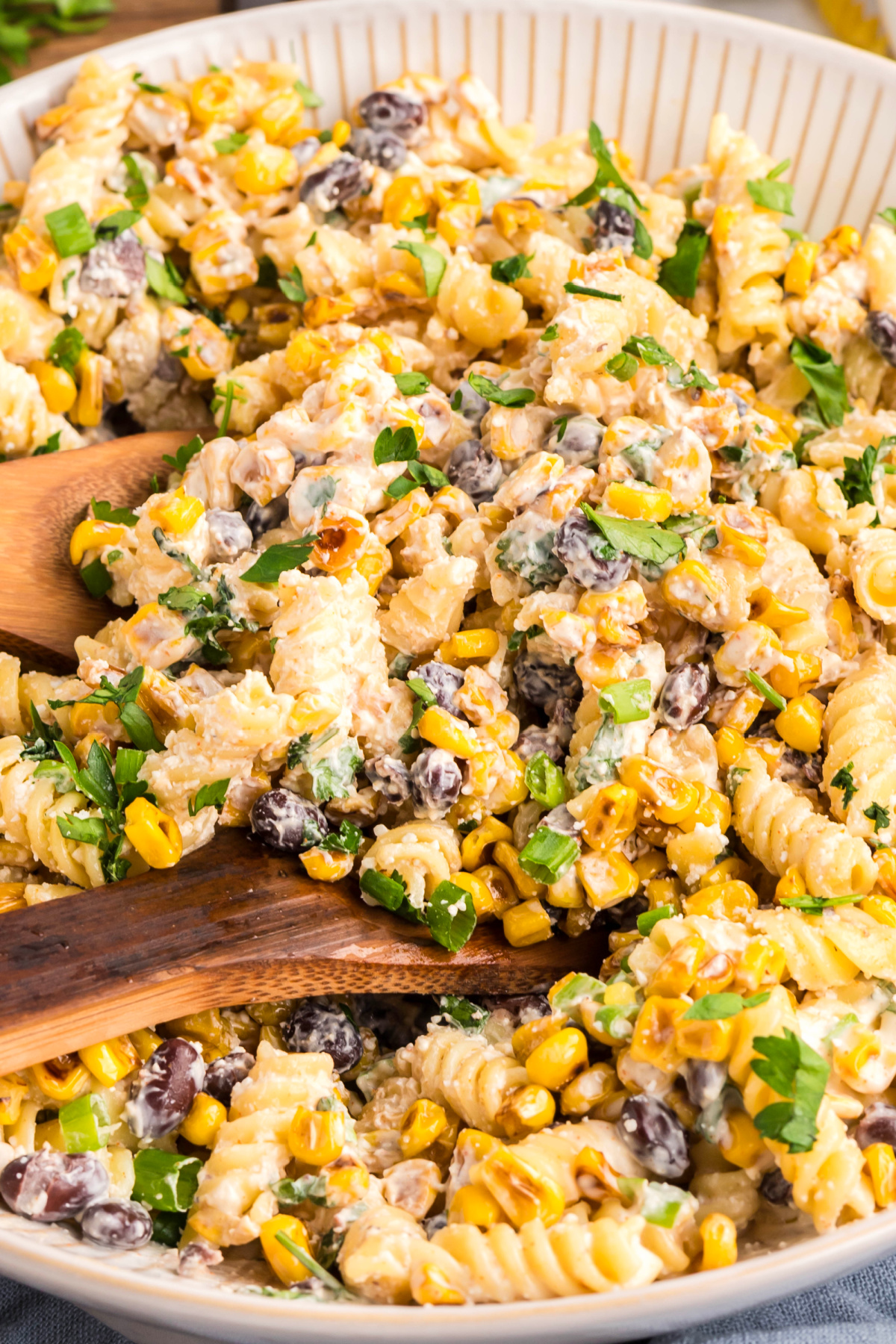 Creamy street corn pasta salad with rotini, black beans, cotija, and chopped herbs