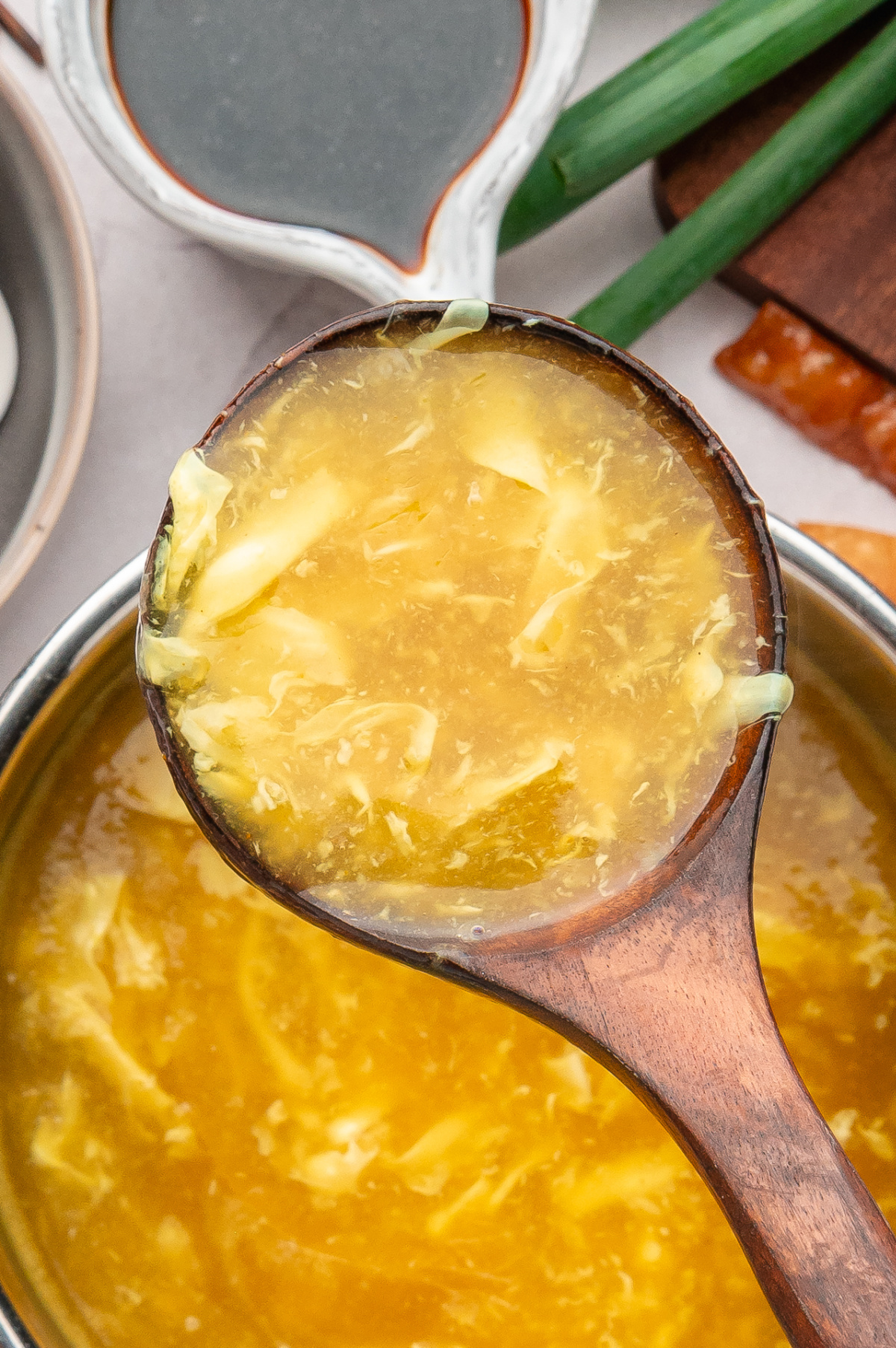 Close-up of egg drop soup showing soft egg ribbons in broth