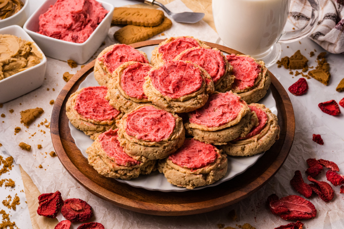 Biscoff butter cookies on a plate with cookie butter and freeze-dried strawberries nearby