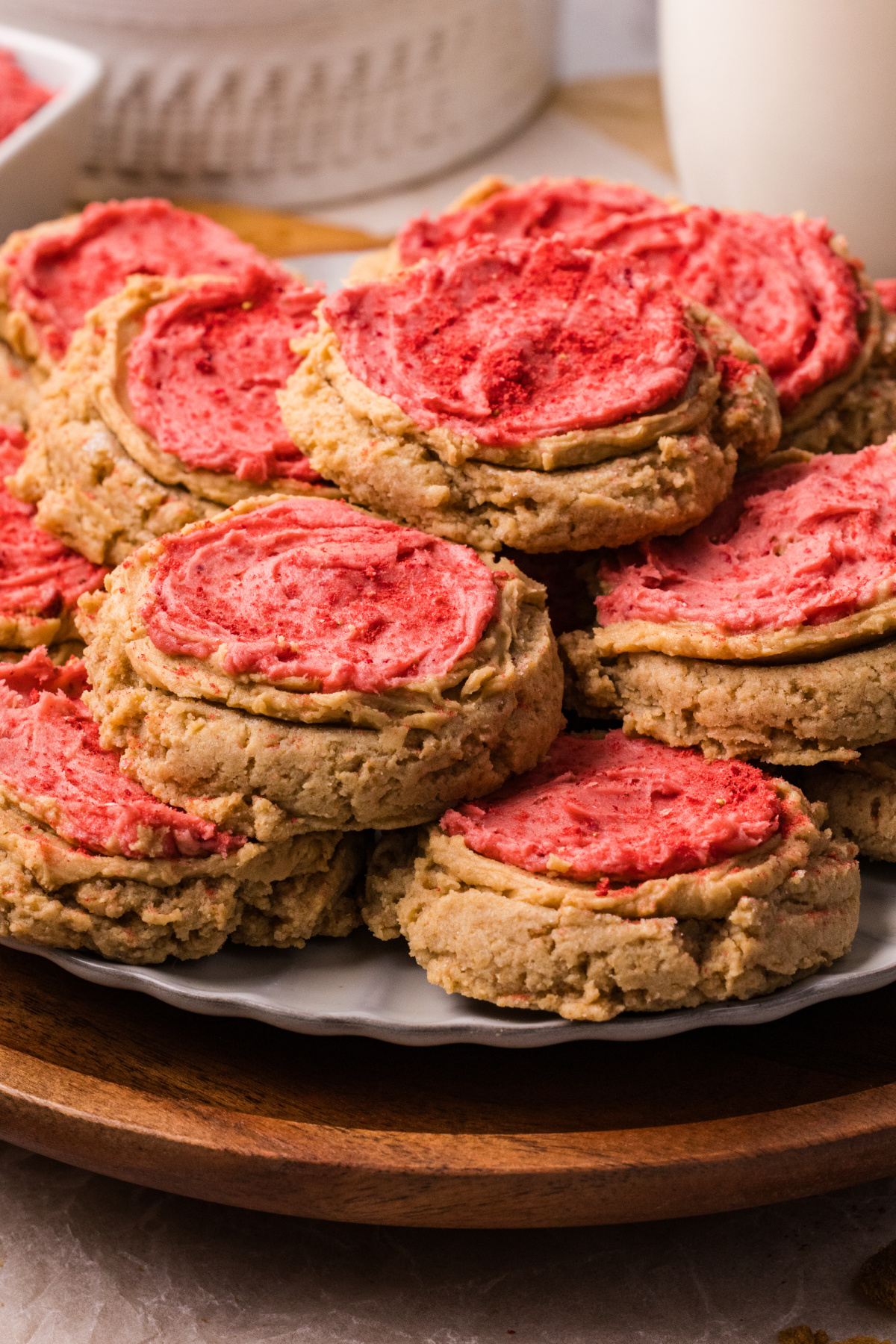 Biscoff butter cookies with strawberry frosting stacked on a plate