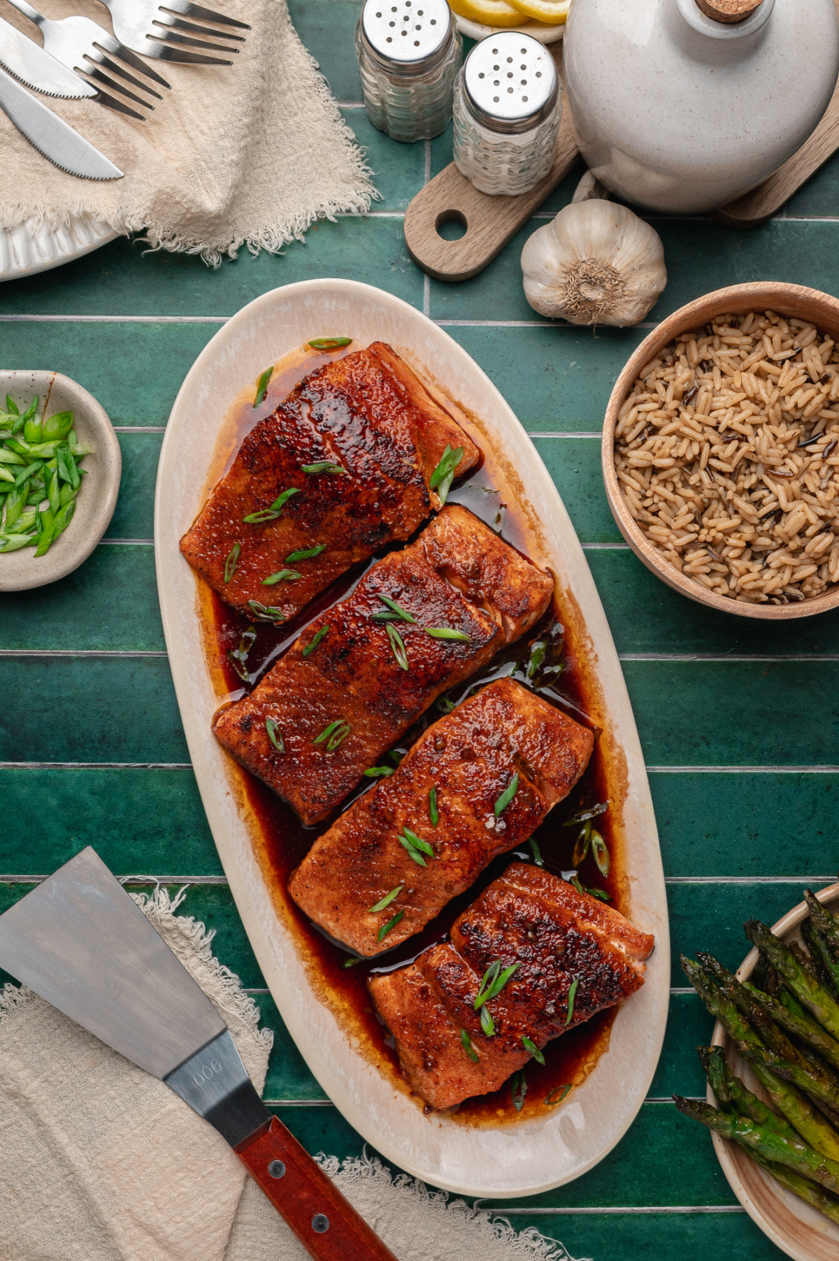 bourbon glazed salmon on a platter with a rich glossy glaze and green onion garnish
