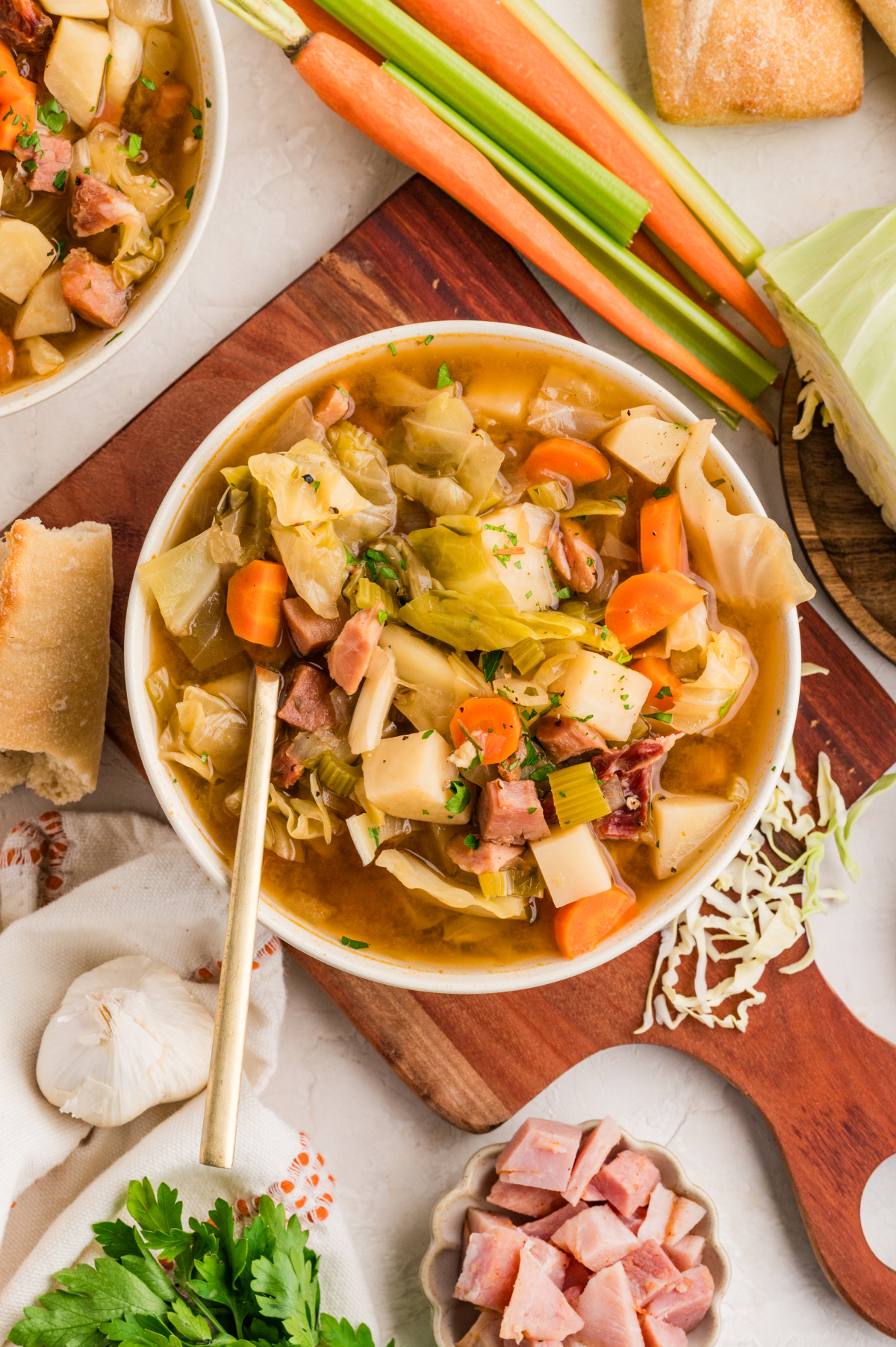 Hearty cabbage soup with ham, potatoes, carrots, and celery in a brothy bowl