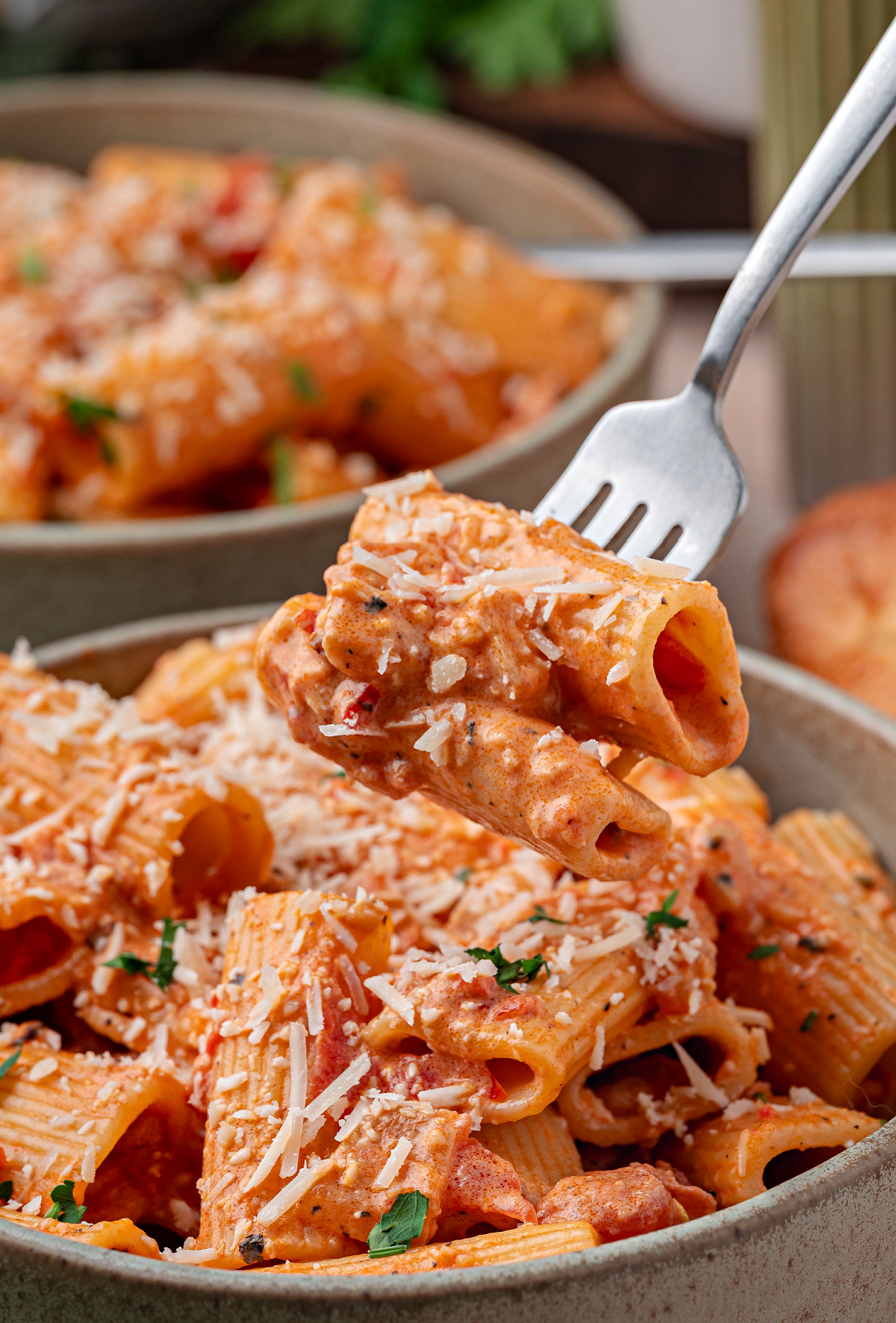 Calabrian chili rigatoni in creamy tomato sauce with Parmesan and parsley on a fork