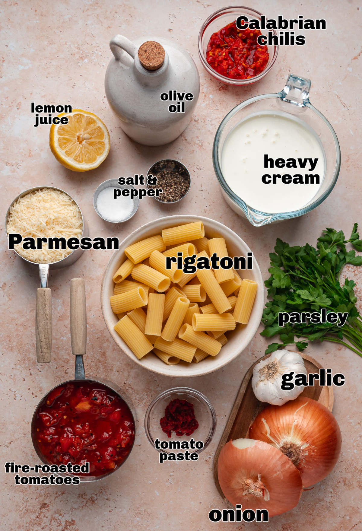 Ingredients for Calabrian chili rigatoni including rigatoni pasta, Calabrian chilis, cream, tomatoes, Parmesan, garlic, and onion