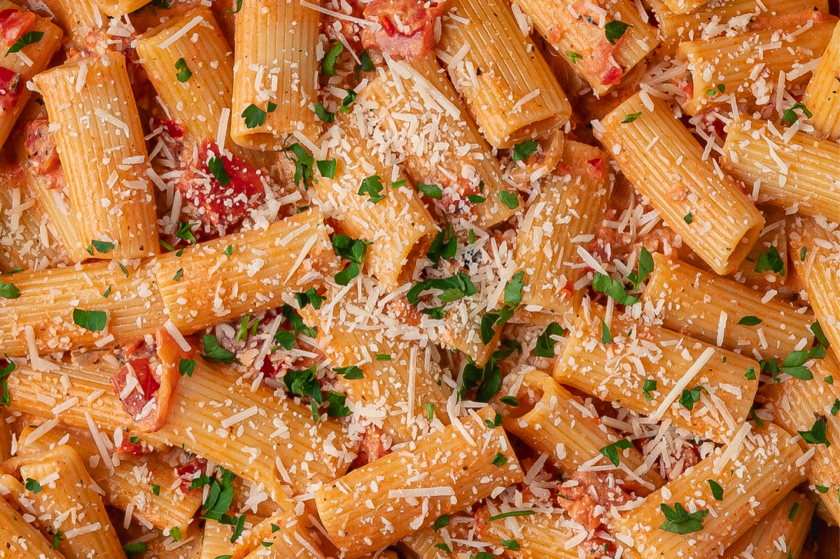 Close-up of Calabrian chili rigatoni with Parmesan, parsley, and creamy tomato sauce