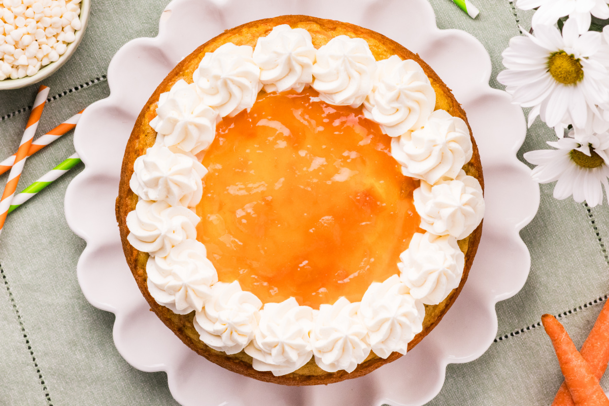 Top view of Carrot Cake with Apricot Filling and White Chocolate Cream Cheese Frosting with piped frosting border and apricot center