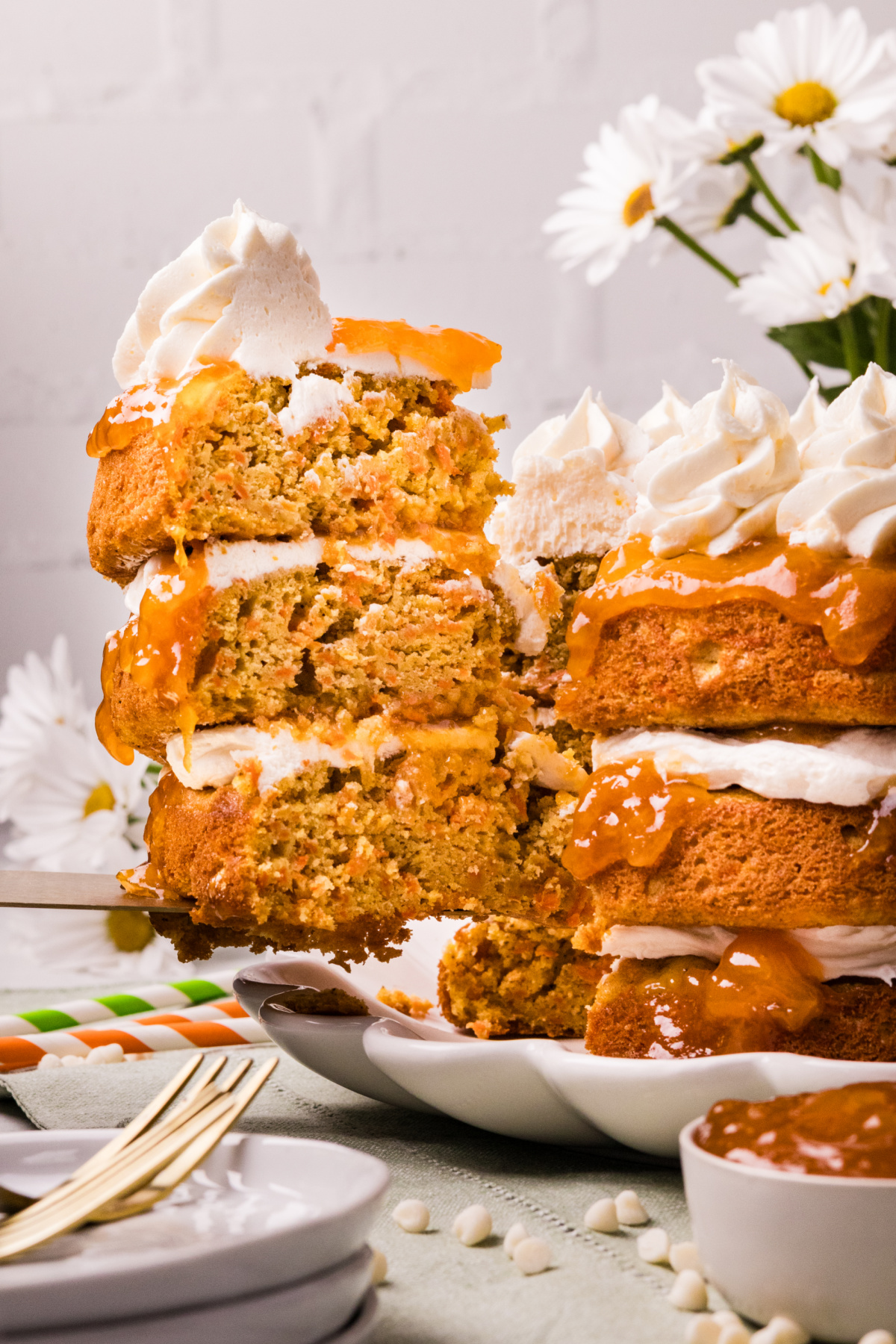 Slice of Carrot Cake with Apricot Filling and White Chocolate Cream Cheese Frosting showing moist crumb and layered filling