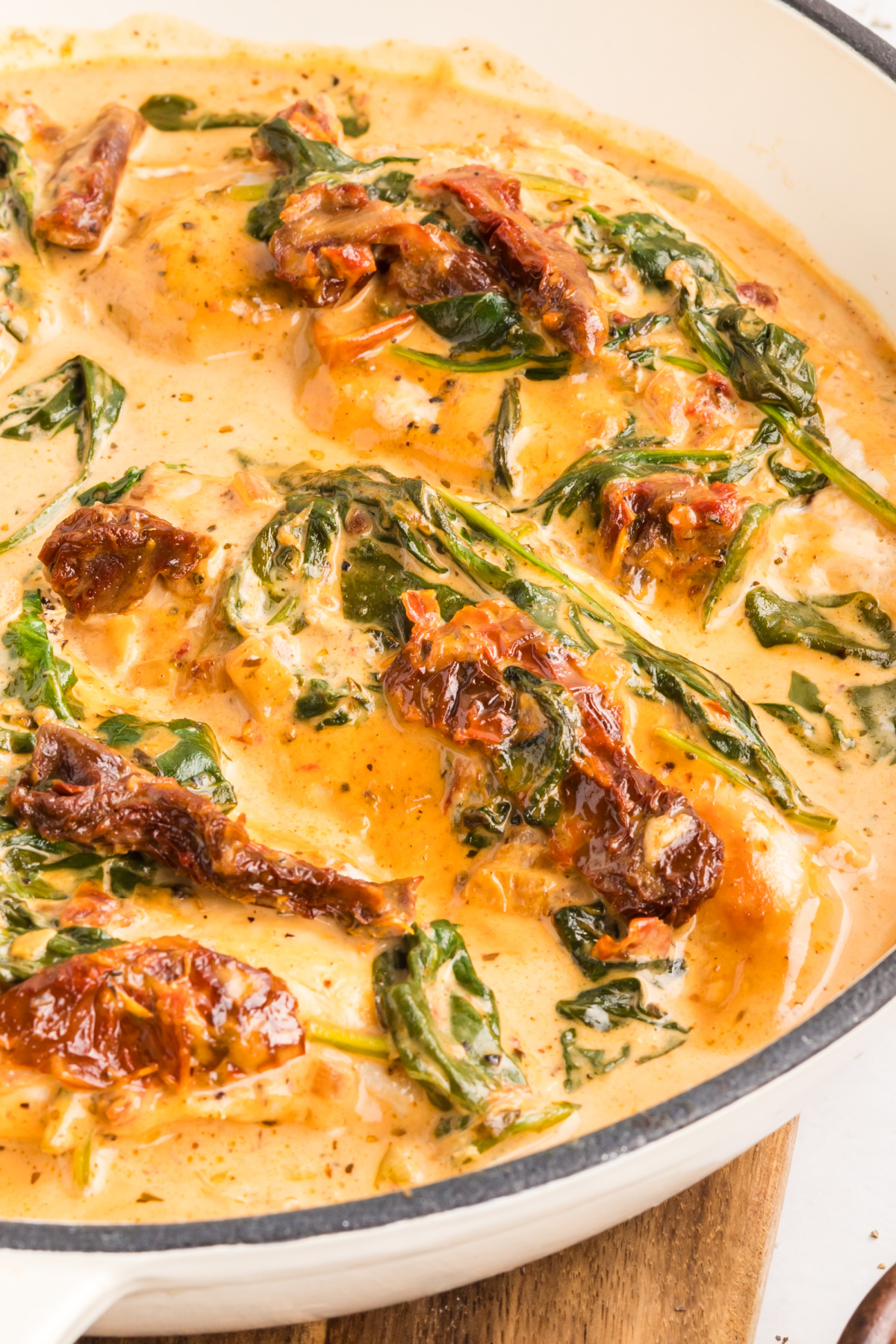 creamy chicken with sun-dried tomatoes and spinach in parmesan sauce close up