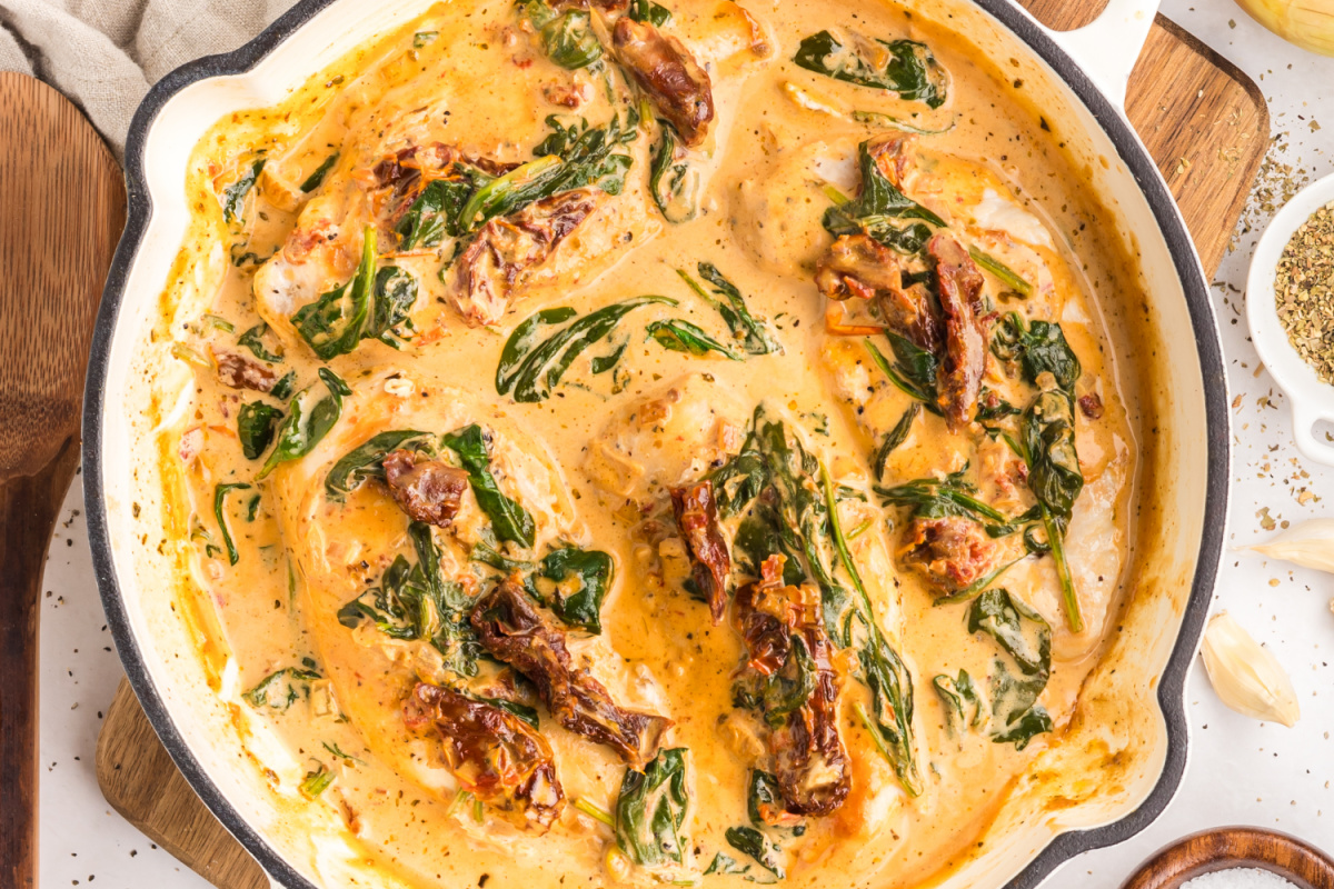 tuscan chicken in creamy parmesan sauce with sun-dried tomatoes and wilted spinach