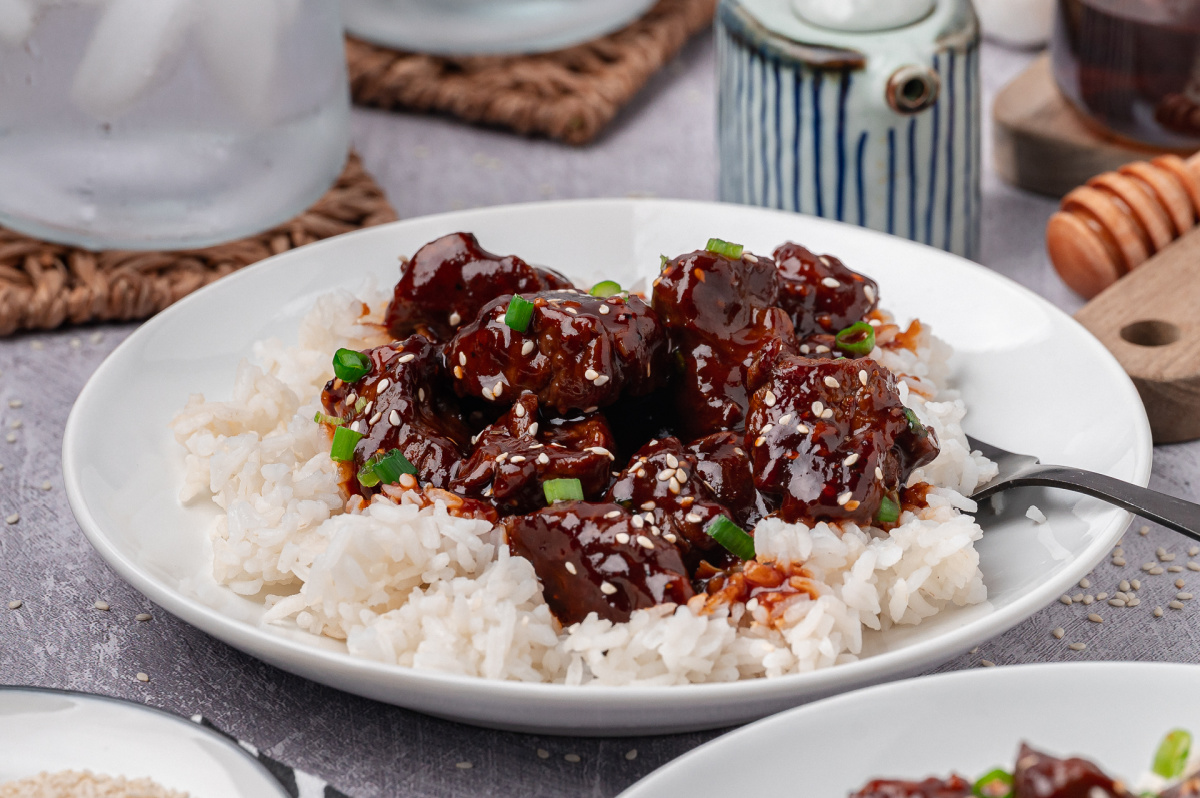 gochujang steak served over white rice with sesame seeds and green onions