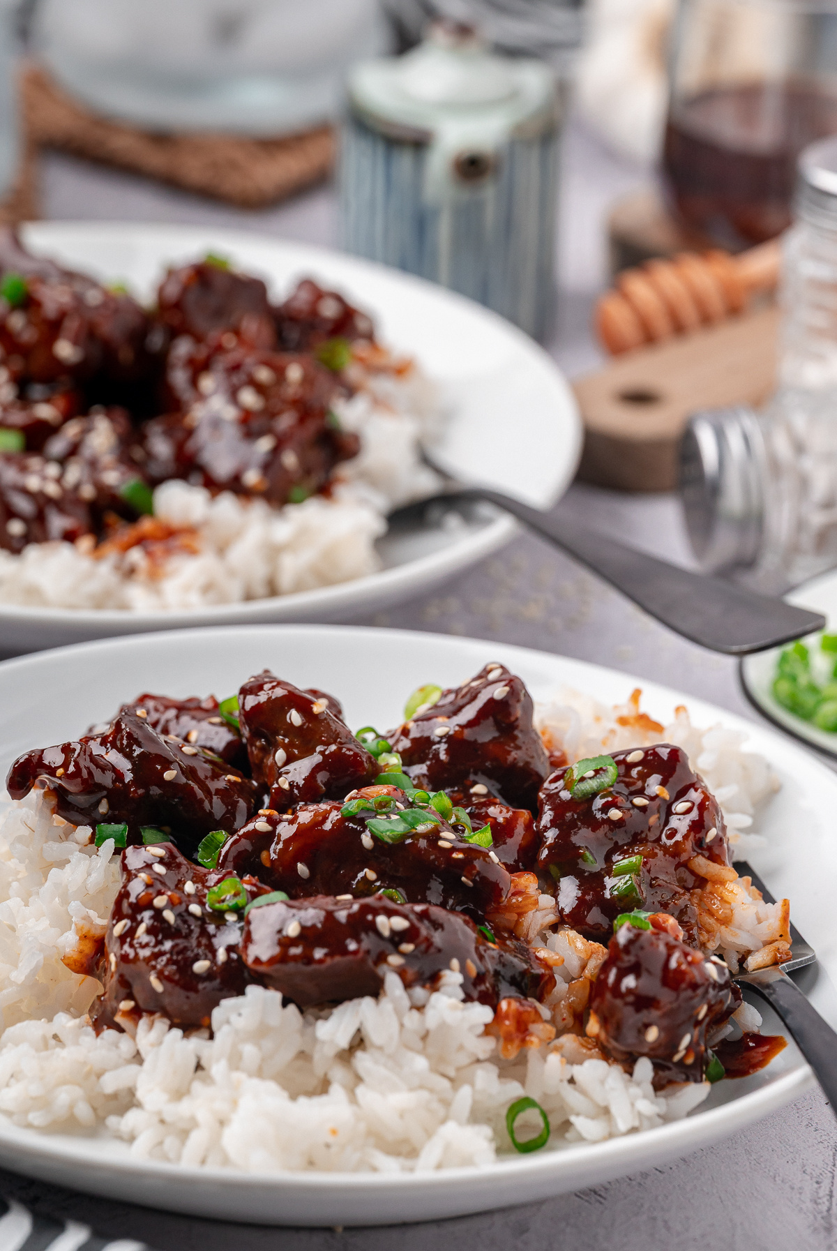 gochujang steak served over white rice with sesame seeds and sliced green onions