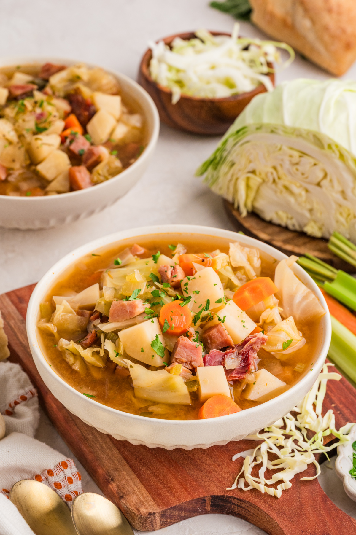 Ham and cabbage soup with potatoes, carrots, cabbage, and ham in broth with ingredients on the side