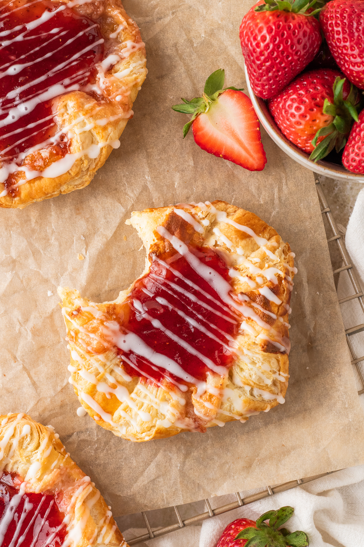 homemade strawberry danish with puff pastry and cream cheese filling with a bite taken out