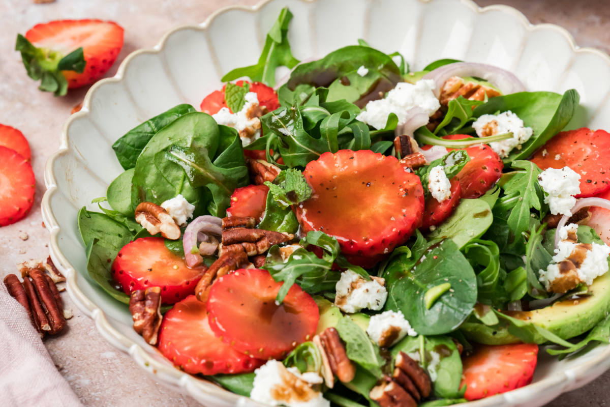 Strawberry goat cheese salad with spinach, arugula, avocado, pecans, and balsamic vinaigrette close-up