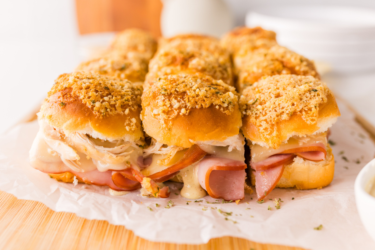 Chicken cordon bleu sliders baked on Hawaiian rolls with ham, melted Swiss cheese, shredded chicken, and a crispy panko topping