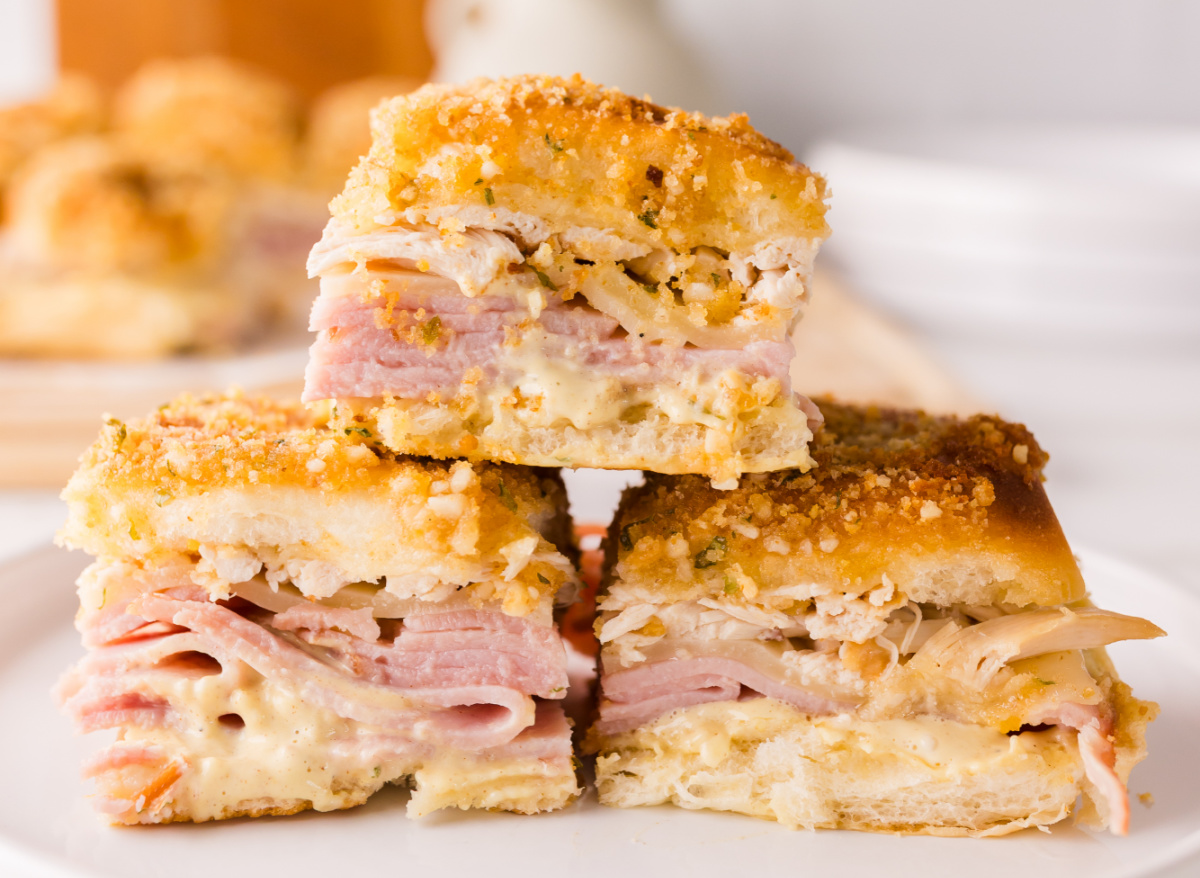 Stacked chicken cordon bleu sliders showing layers of ham, melted Swiss cheese, shredded chicken, and crispy panko topping