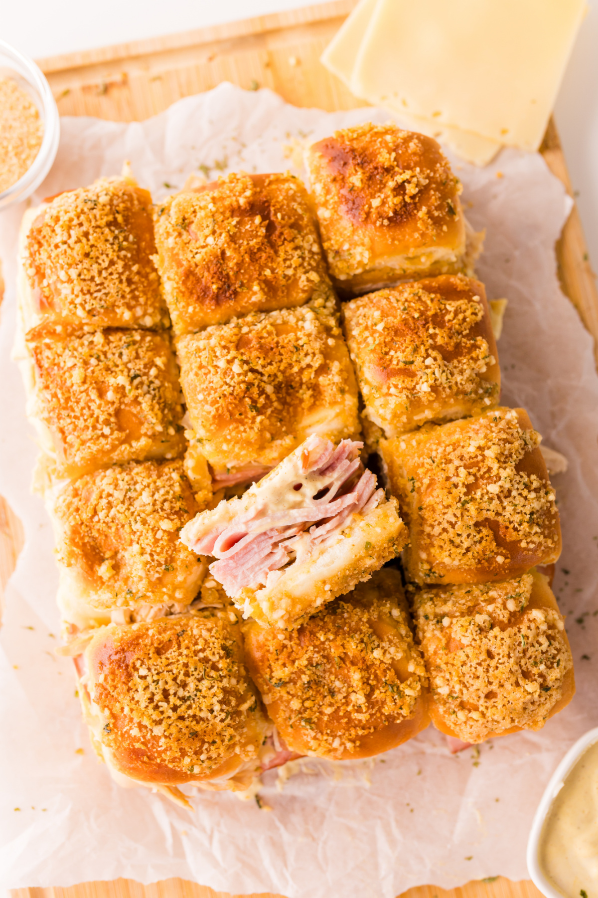 Overhead view of baked cordon bleu sliders with crispy panko topping and layers of ham, Swiss cheese, and chicken