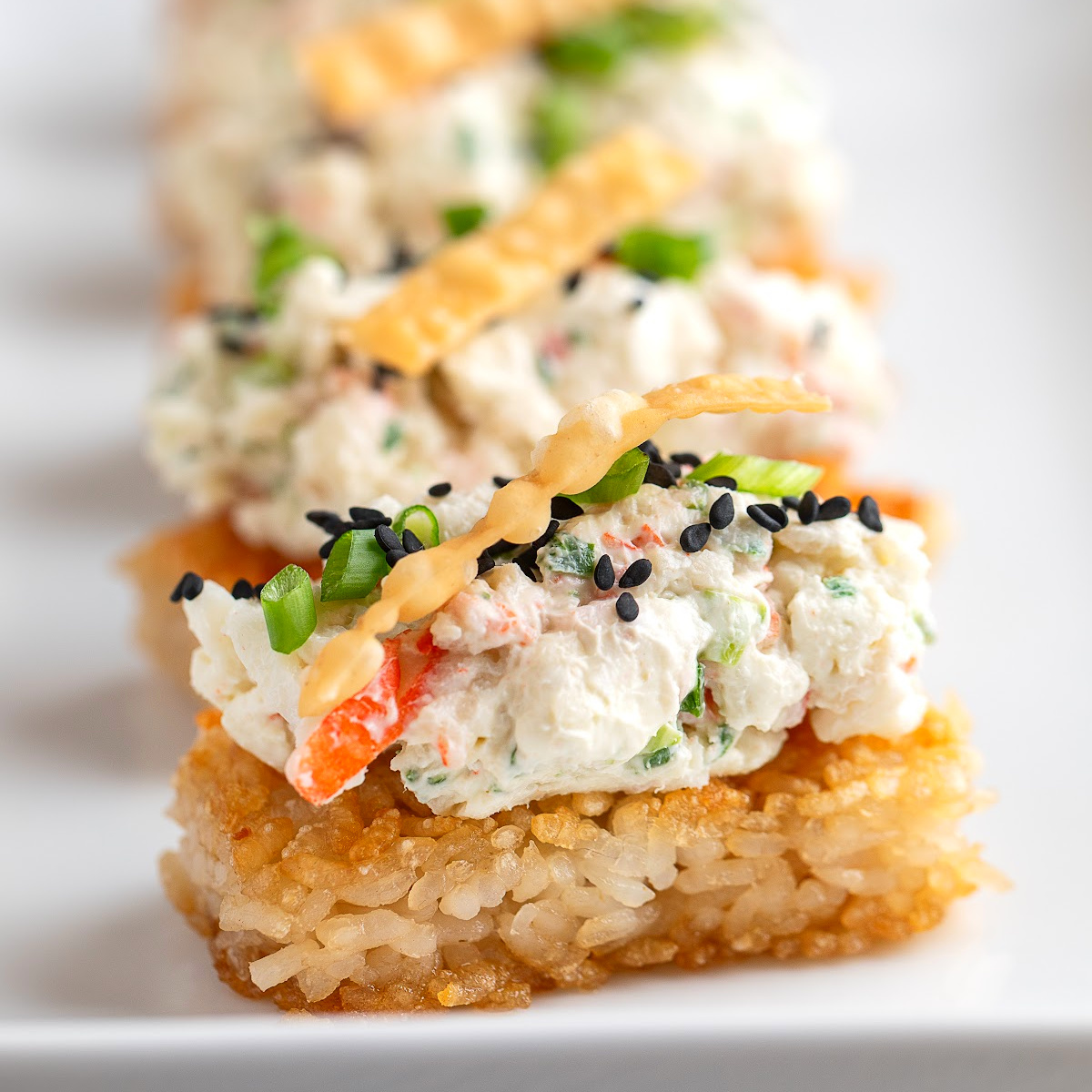 Crispy Rice Crab Rangoon Bites appetizer with creamy crab topping on golden crispy rice squares