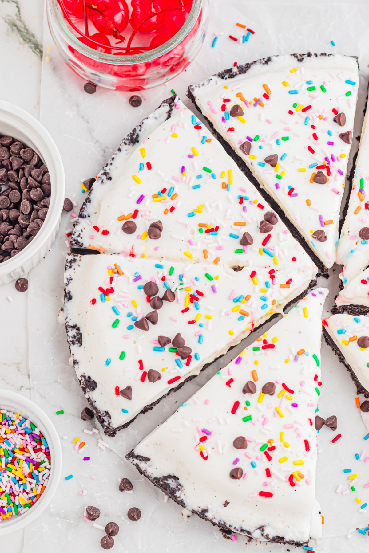 close up of ice cream pizza slices with Oreo crust, sprinkles, and chocolate chips