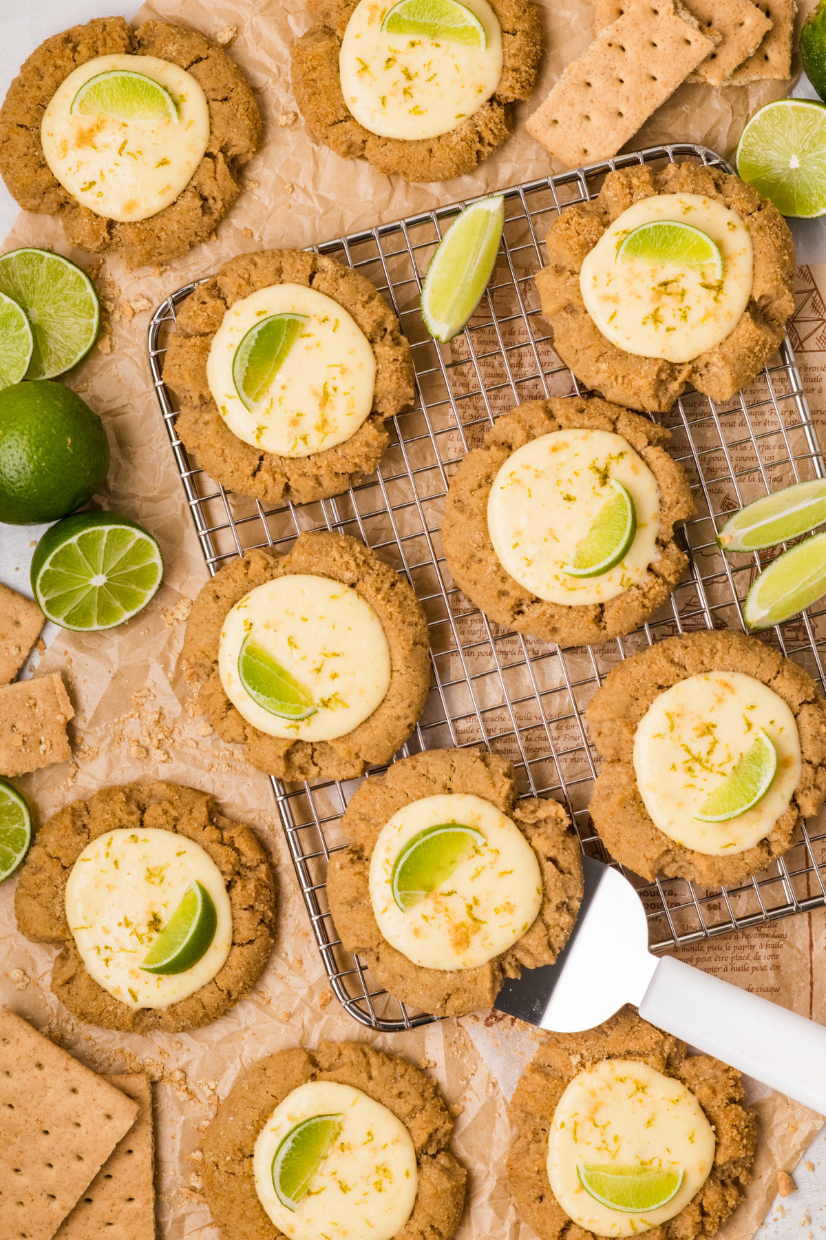 key lime pie cookies on cooling rack with creamy lime centers and fresh lime slices