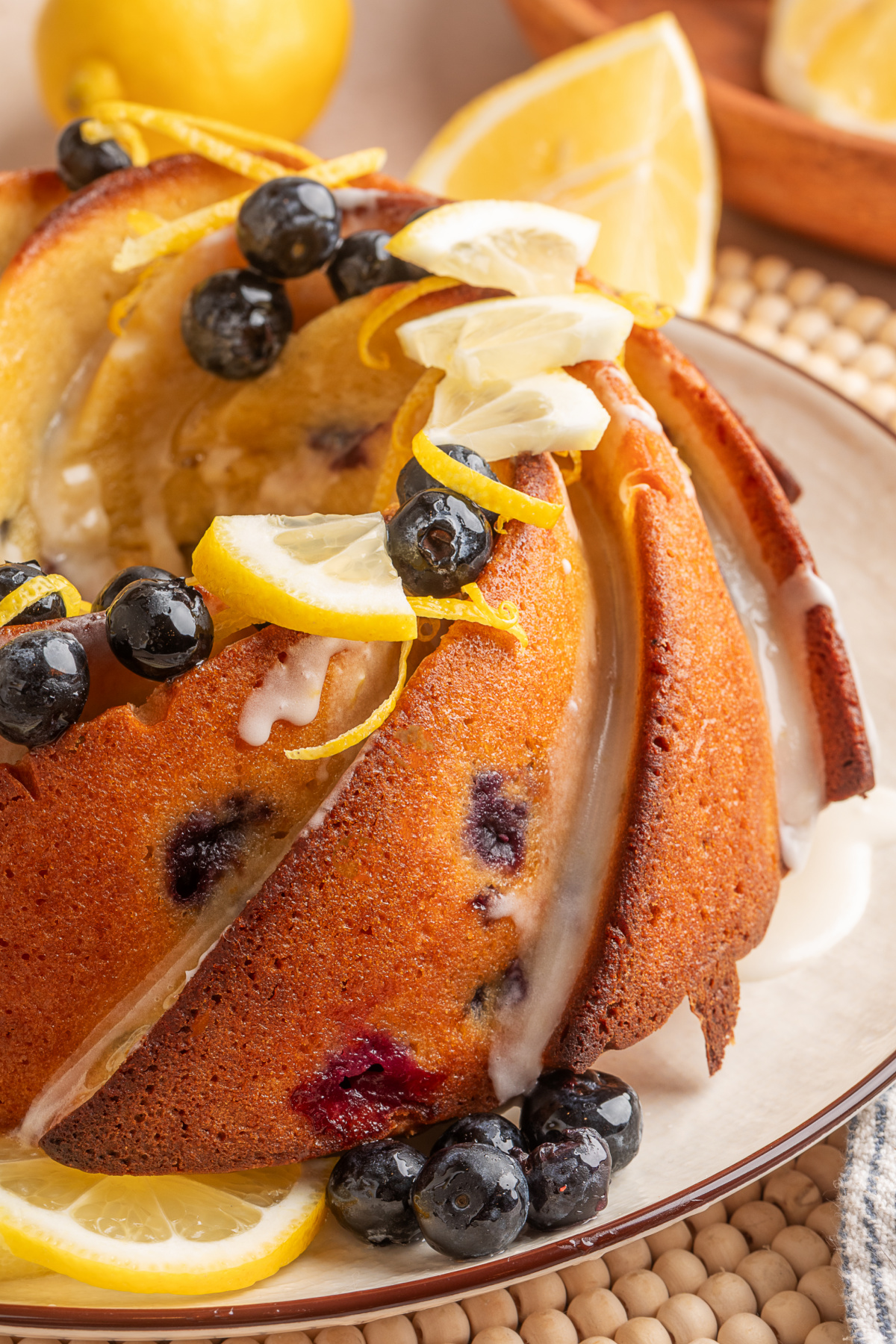 Lemon blueberry sour cream bundt cake with lemon glaze, fresh blueberries, and lemon slices on top