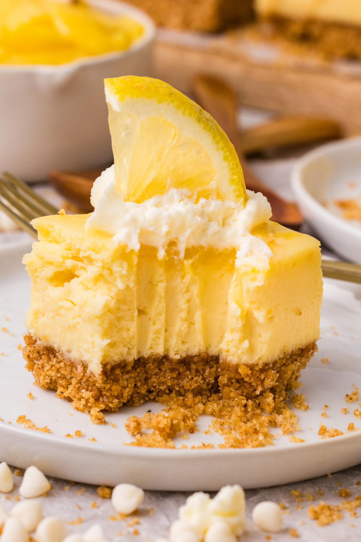 bitten lemon cheesecake bars showing creamy center and graham cracker crust