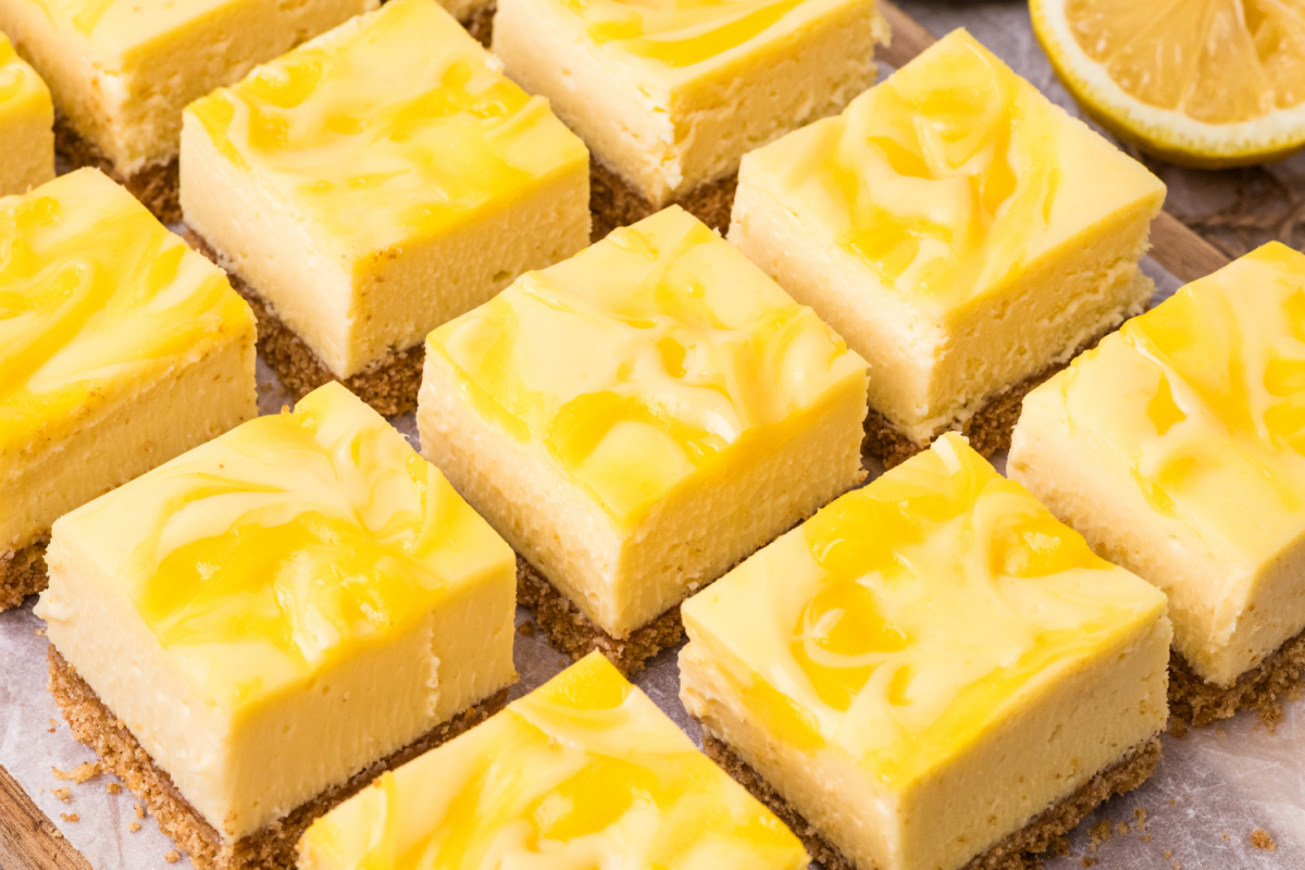 sliced lemon cheesecake bars with lemon curd swirl and graham cracker crust