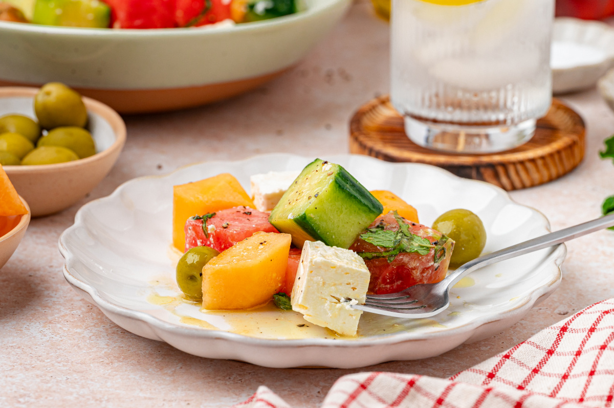 melon and feta Greek-style salad with cucumber, olives, and herbs served on a plate
