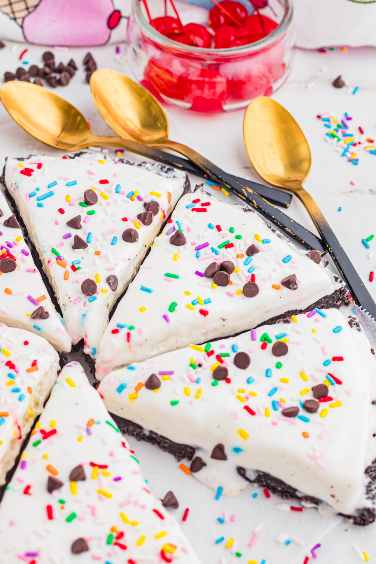 no bake ice cream pizza slices with Oreo crust, sprinkles, and chocolate chips on a platter