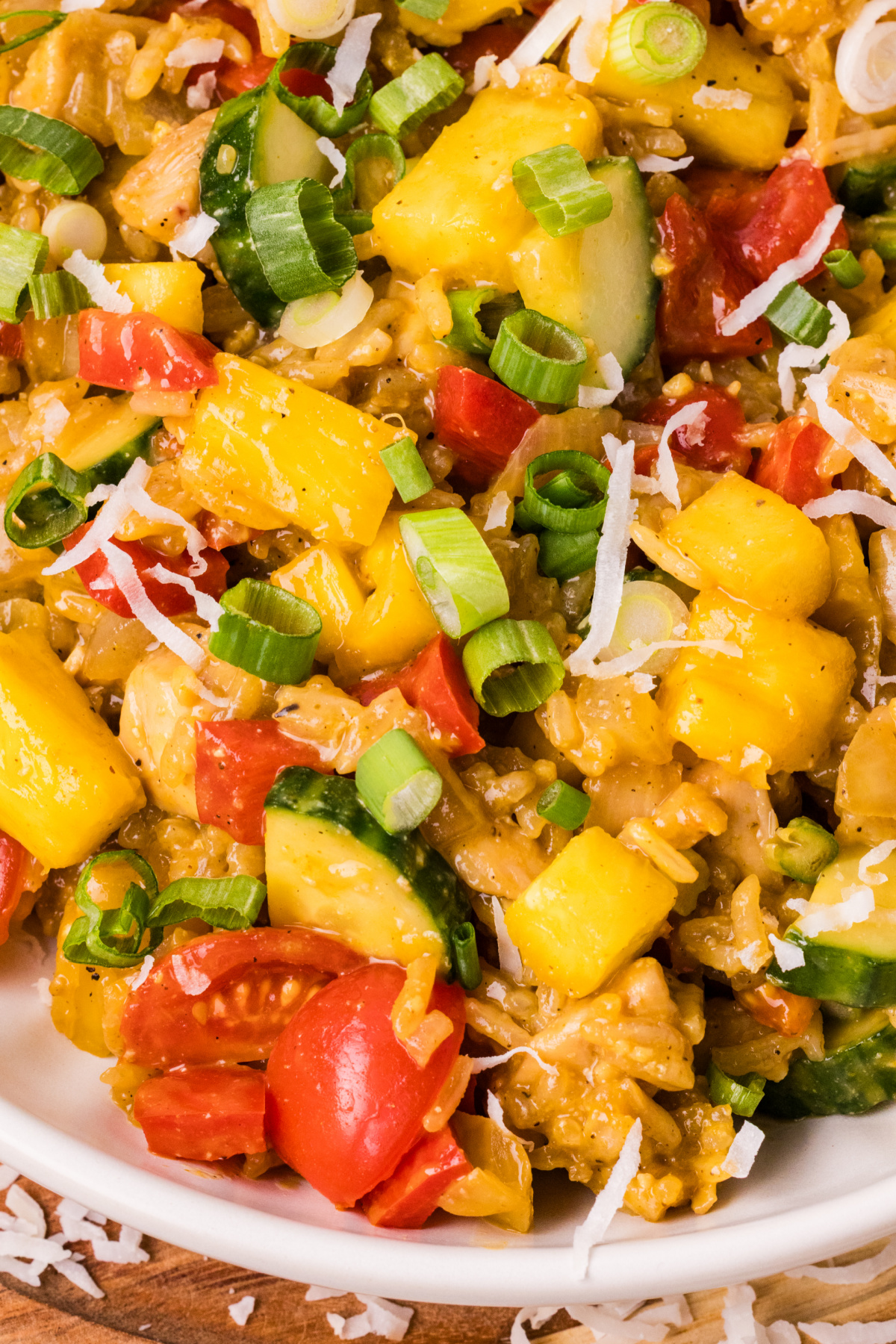 pineapple chicken and rice close up with coconut rice, pineapple, cucumber, and green onions