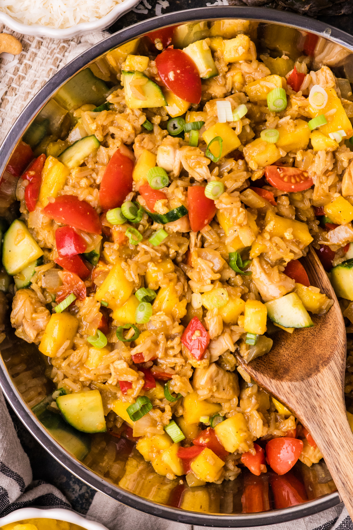 pineapple chicken and rice in a skillet with coconut rice, chicken, pineapple, and vegetables