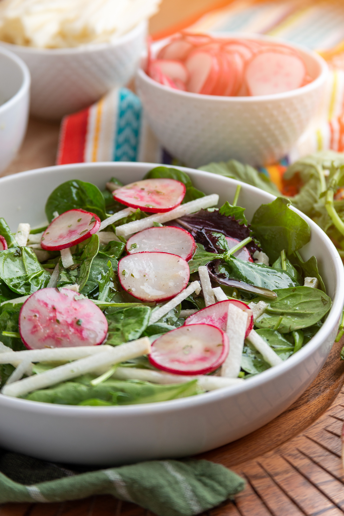 radish and jicama salad with lime vinaigrette served in a bowl with fresh greens