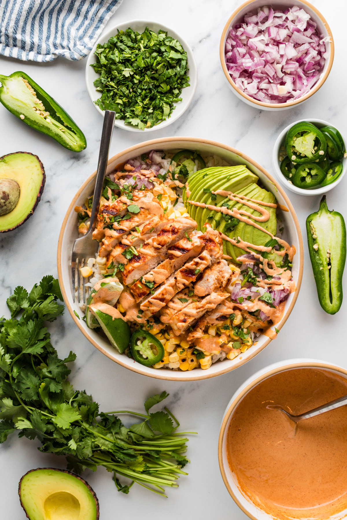 street corn chicken rice bowls with grilled chicken, charred corn, avocado, cilantro, jalape&ntilde;os, and creamy elote-style sauce