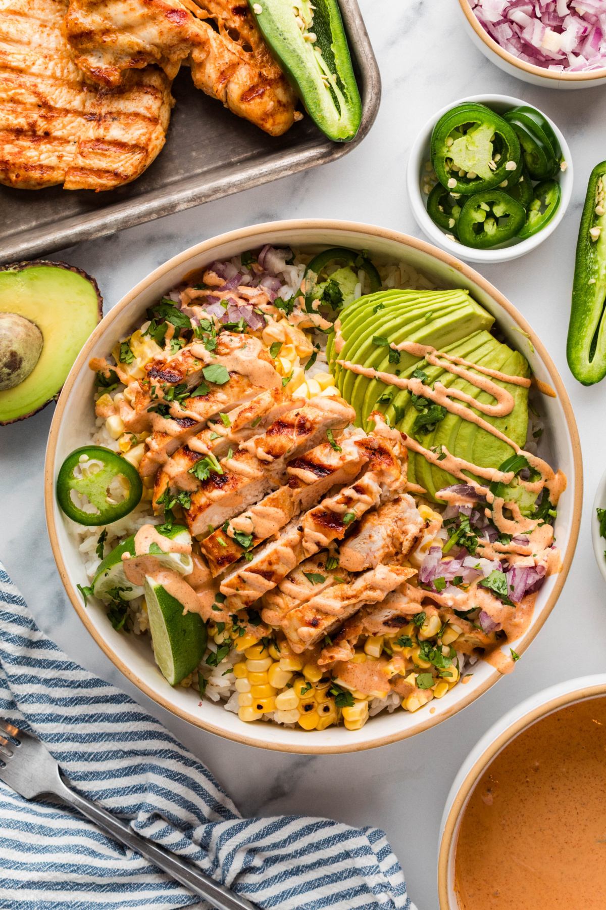 Street corn chicken rice bowls with grilled chicken, charred corn, avocado, and creamy elote-style sauce over rice