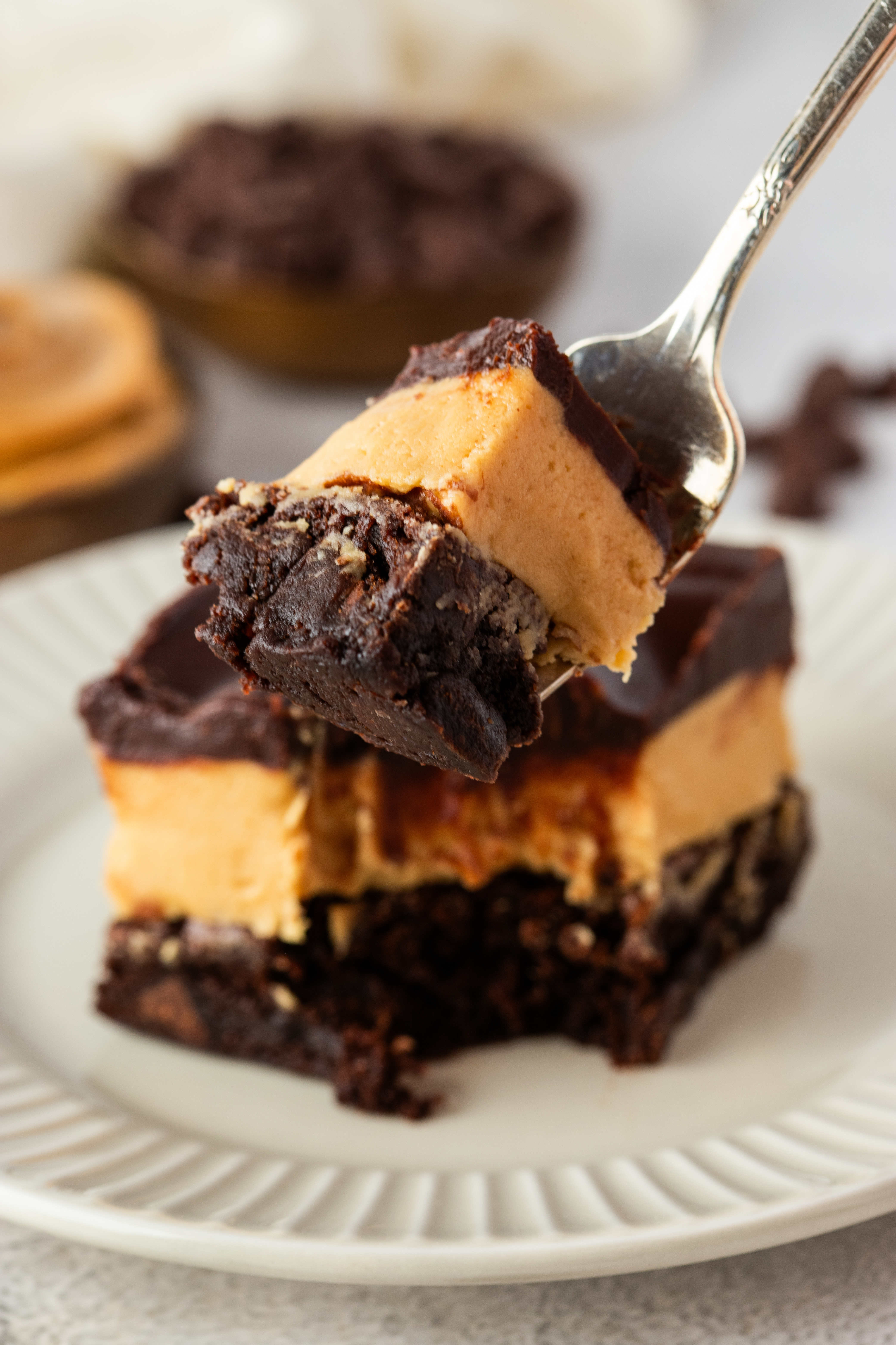 Fork lifting a bite of Buckeye brownies with thick peanut butter filling and fudgy chocolate brownie base