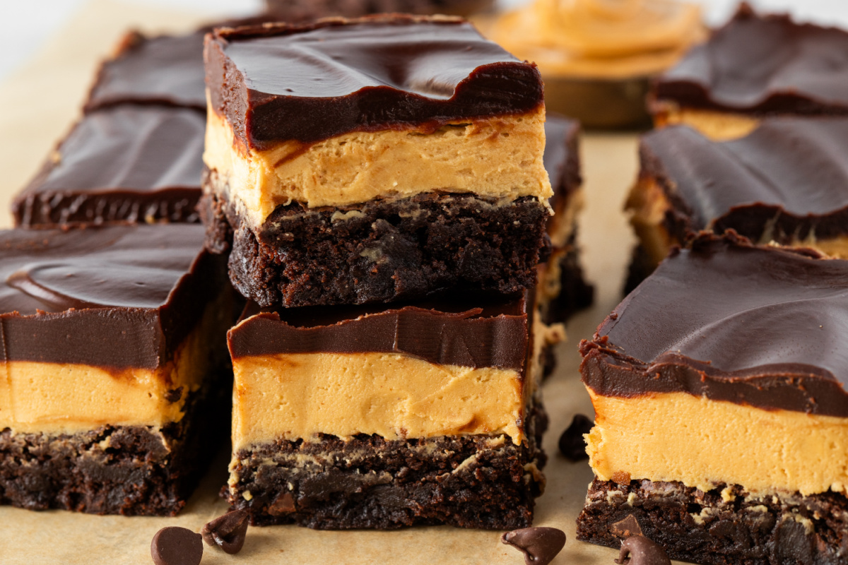 Layered Buckeye brownies with thick peanut butter layer and glossy chocolate ganache