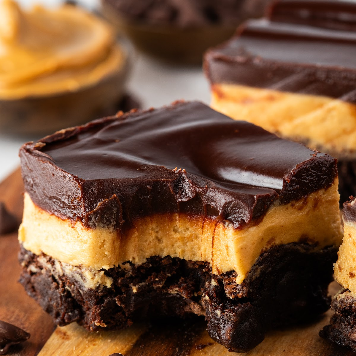 Layered Buckeye brownies stacked with thick peanut butter filling and dark chocolate ganache