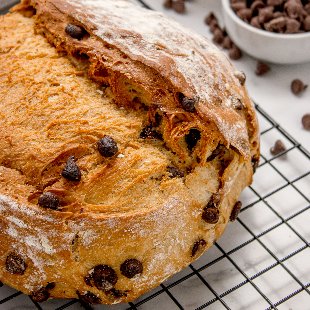 Chocolate Chip Artisan Bread on a cooling rack showing golden crust and rustic loaf shape