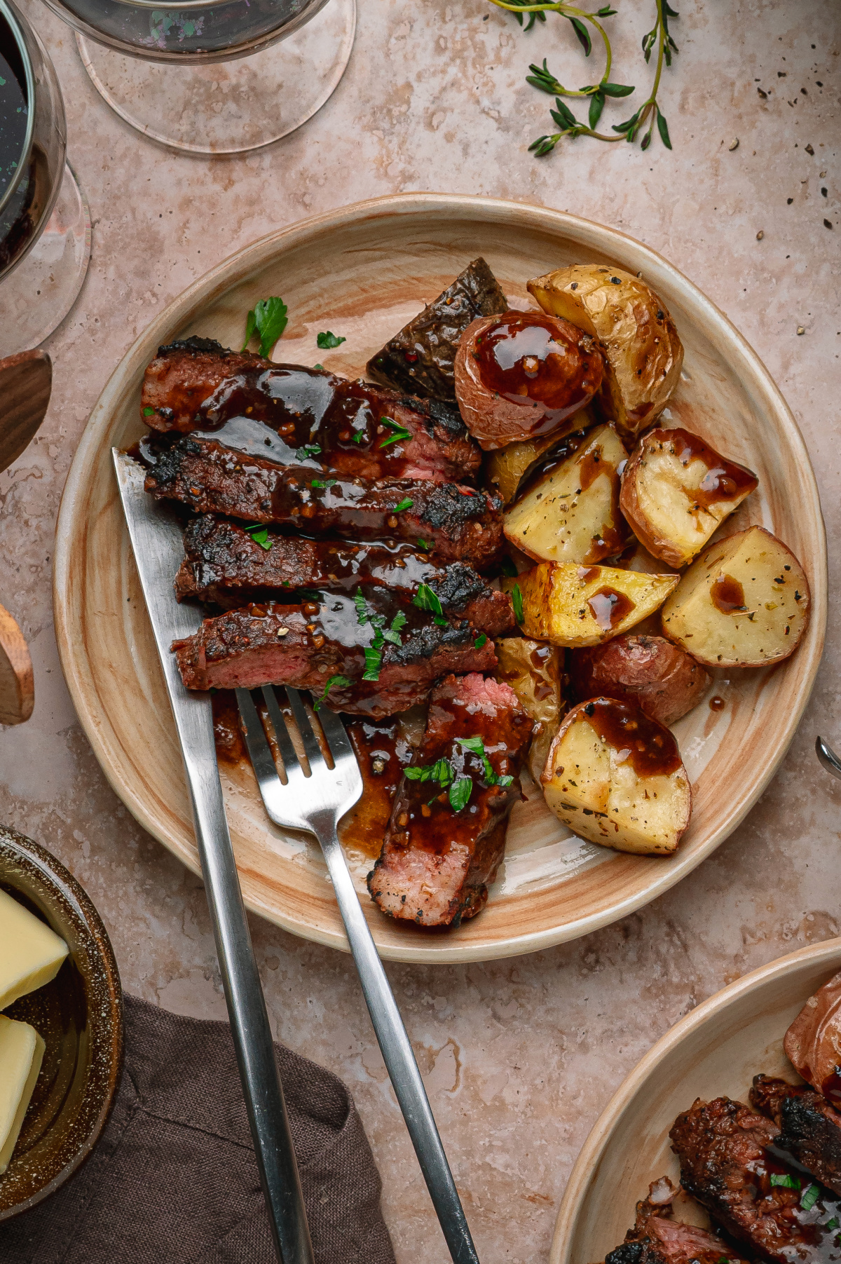 Cocoa rubbed steak with dark stout pan sauce served sliced with roasted potatoes on a dinner plate.