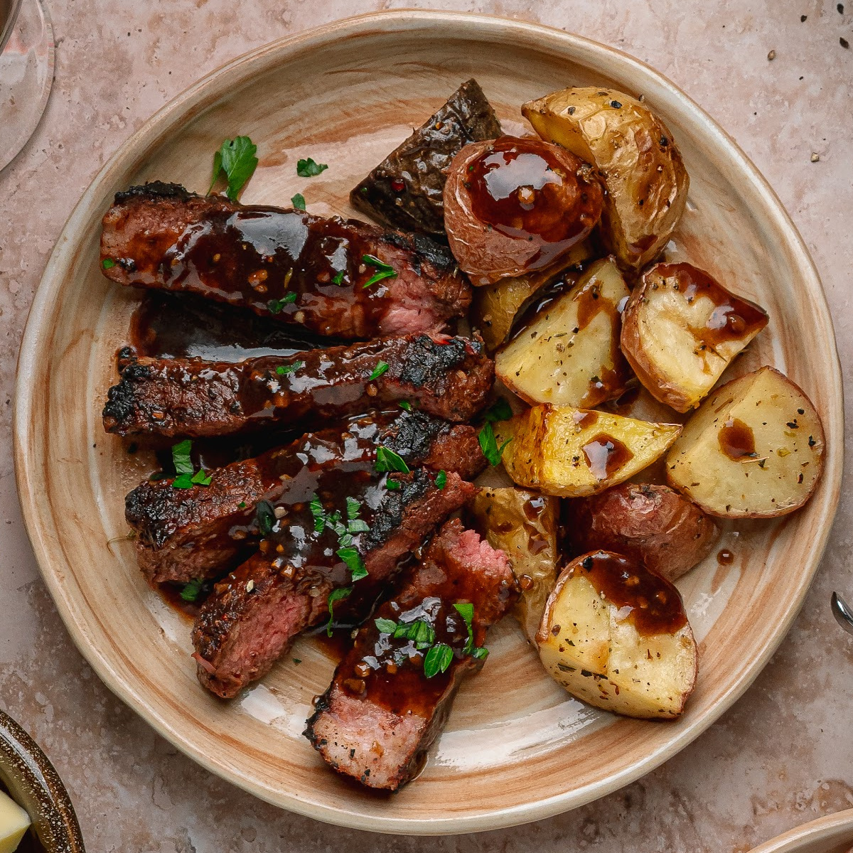 Close-up of cocoa rubbed steak with dark stout pan sauce and roasted potatoes.