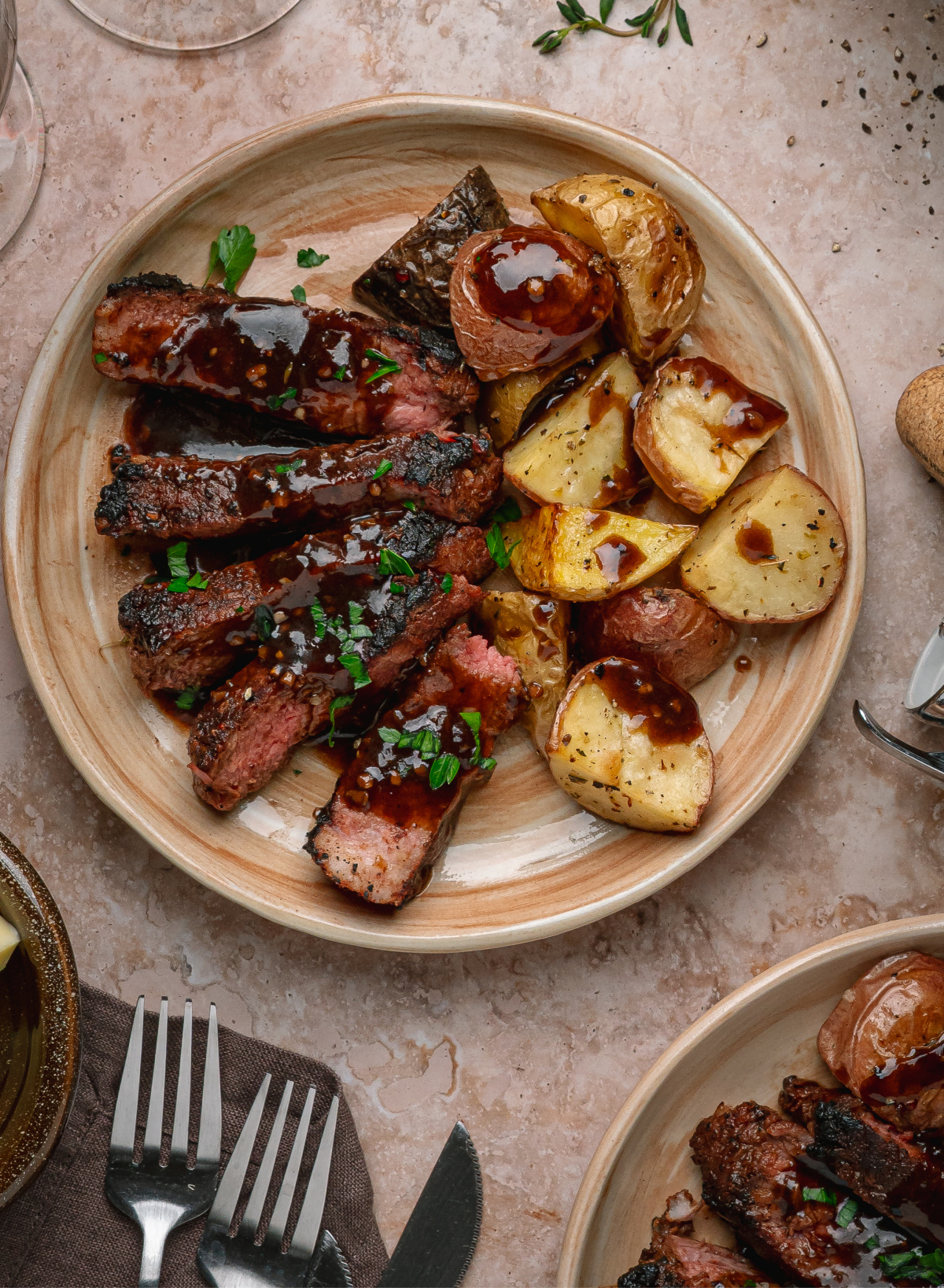 Cocoa rubbed steak served with roasted potatoes and dark stout pan sauce on a dinner plate.