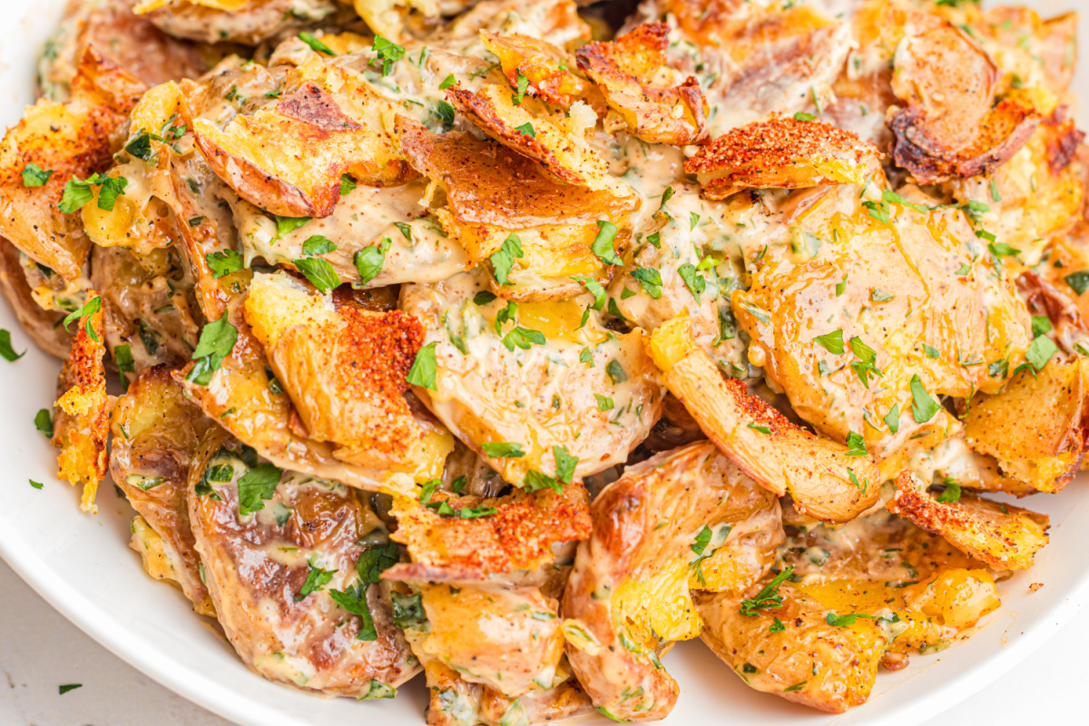 Close-up of Crispy Smashed Potato Salad with creamy lemon herb dressing, roasted baby potatoes, fresh parsley, and crispy golden potato edges